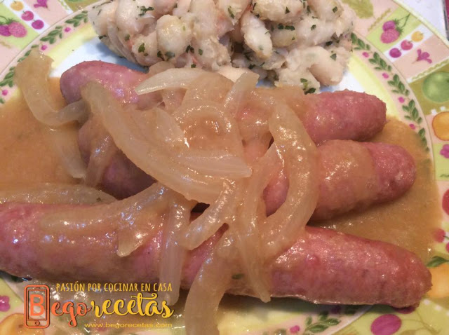 Salchichas encebolladas con alubias blancas salteadas